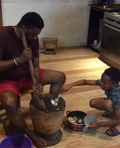 Kunle Afolayan Passes Culinary Skill To His Son, Teaches Him How To Pound Yam