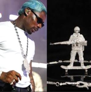 Asake wearing a custom $500K skating soldier diamond chain with detailed pendant and icy diamonds