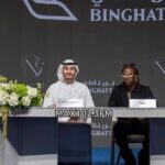 Rema signs documents after purchasing a luxury home at One by Binghatti in Dubai.